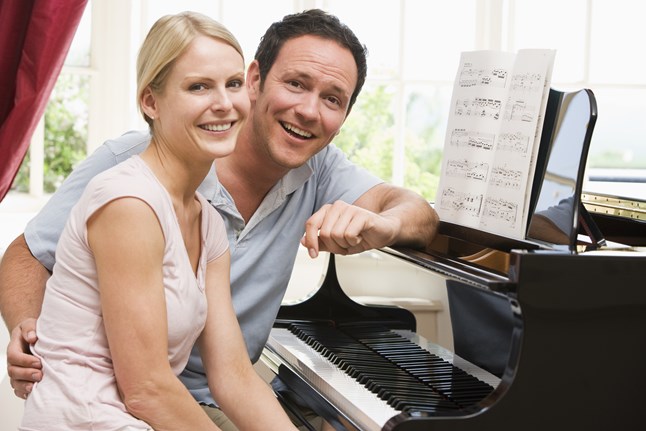 couple-sitting-at-piano-smiling_StEghhcRBs.jpg